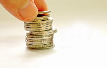 coins stacks with a hand picking up on white background