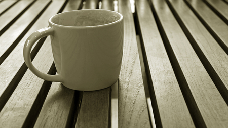 Cup of drunk coffee with coffee ground on old wooden table