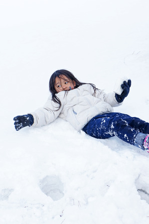 little girl playing on the snowの写真素材