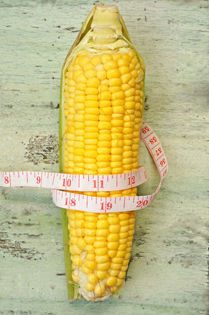 fresh corn with measuring tape (diet concept)の写真素材