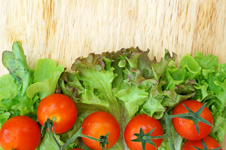 Tomatoes and lettuce on wooden backgroundの写真素材