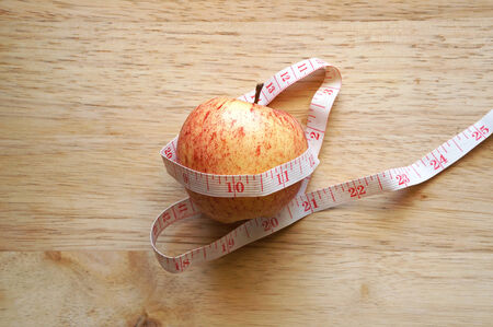 Apple wrapping with measuring tape on wooden table
