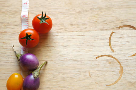 Fresh tomatoes with coffee stain on wooden tableの写真素材