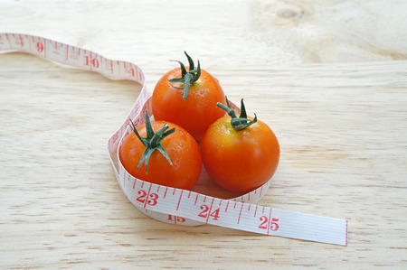 Cherry tomatoes wrapping with measuring tape  diet concept の写真素材