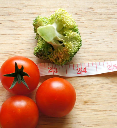 Broccoli and tomatoes with measuring tape (diet concept)の写真素材