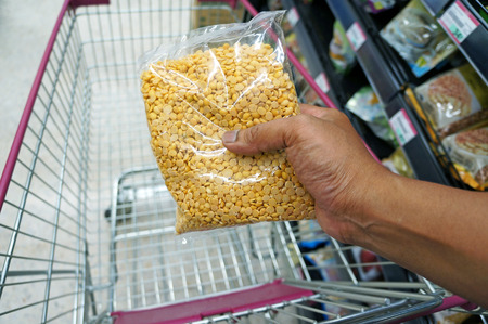 Close up of hand buying nuts at supermarketの写真素材