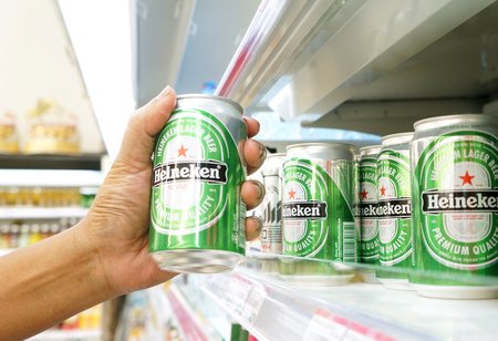 BANGKOK, THAILAND - MAY 13, 2014: Customer pick a heineken beer can from shelf at supermarket. Heineken International is a Dutch brewing company, founded in 1864 in Amsterdam, famous all over the world.のeditorial素材