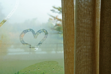 draw heart on glass at window