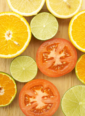 Different sliced juicy citrus fruits on wooden tableの写真素材