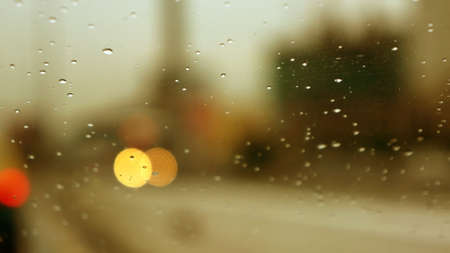 Drop on a glass window and a blurred landscape on the backgroundの写真素材
