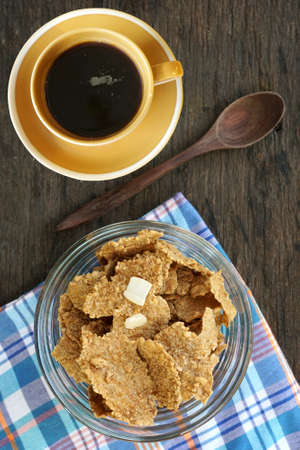 Breakfast cereal with a black coffee on a wooden board
