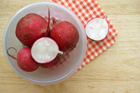 Radish in bowl on wooden table