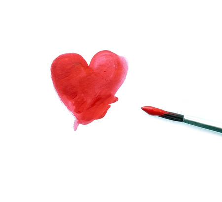 Painted red heart and a brush isolated over whiteの写真素材
