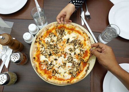 Top view image of human hand picking pizzaの写真素材