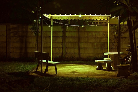 Bench under lamp In home garden during the nightの写真素材