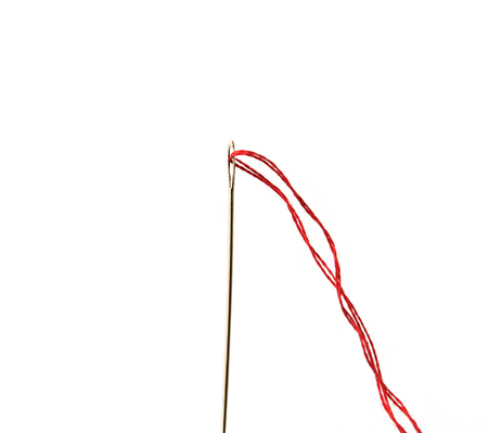 Red thread and needle isolated on whiteの写真素材