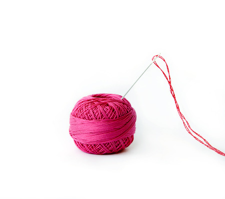Red thread ball and needle with red thread isolated on whiteの写真素材