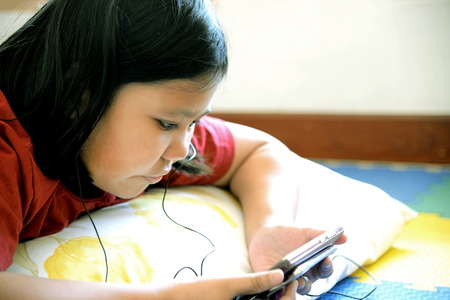 Little asian girl using smartphone