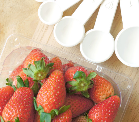 Measuring spoons cup with strawberryの写真素材