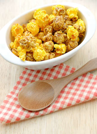 Popcorn in white bowl over wooden backgroundの写真素材