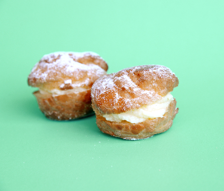 Profiterole or cream puff with filling and powdered sugar toppingの写真素材