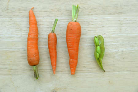 Carrots and peas on wooden background.の写真素材