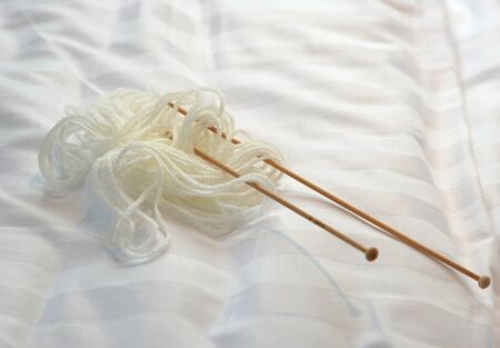 white wool knitting on white bed