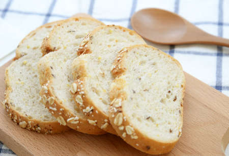 Sliced white bread on wooden plate