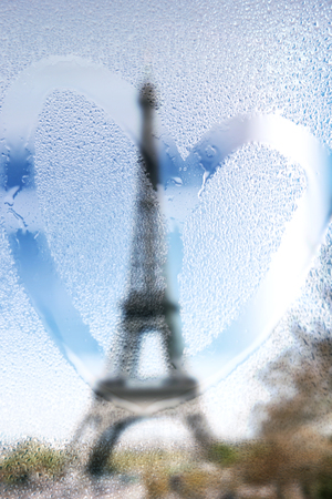 France, Paris, Eiffel Tower in a rainy day with draw heart on wet glassの写真素材