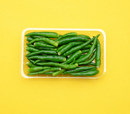 green hot peppers on yellow (pop art style)の写真素材
