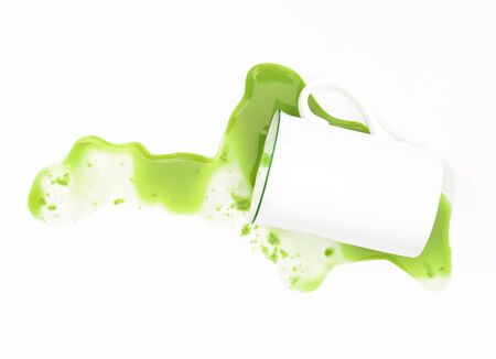 spilled green tea from a cup isolated on whiteの写真素材