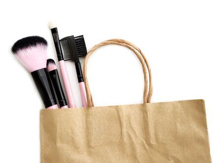 Shopping cosmetic brushes in paper bag isolate on white.の写真素材
