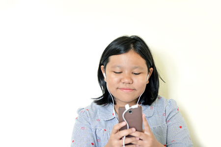 Happy girl listening to the music from a smartphoneの写真素材