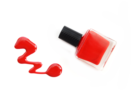 red nail polish bottle with splatters isolated on white backgroundの写真素材