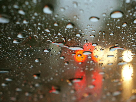 Rain drops on window with street bokeh lightsの写真素材