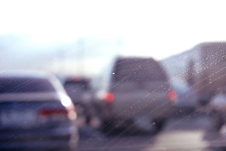 Car glass with unclean texture. Blurred road on background.の写真素材