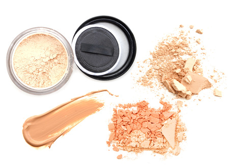 Face powder and brush over white background