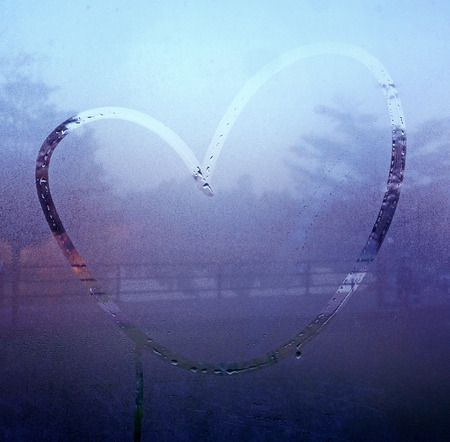 drawn heart on the wet glassの写真素材