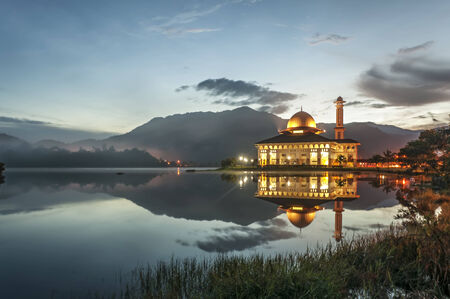 Moving clouds over the mosque with reflection on the lake gardenの写真素材