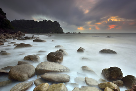 Seascape -  Seashore with misty water and rock at cloudy sunrise の写真素材