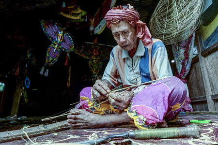 KOTA BHARU, MALAYSIA - FEBRUARY 19 : The master kite maker, Shafie Bin Jusoh works on his craft in a...