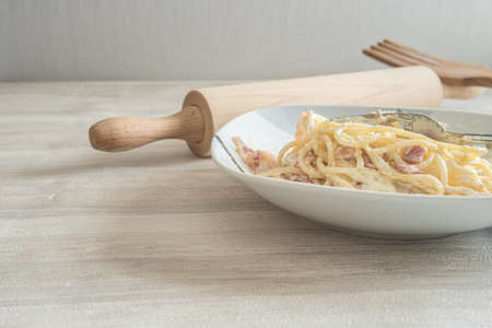 spaghetti to bacon and egg for dinner on porcelain plateの写真素材