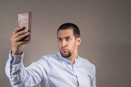 beautiful young man making a selfie with shirtの写真素材