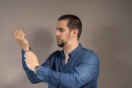 a gentleman with a beard buttoning a shirtの写真素材