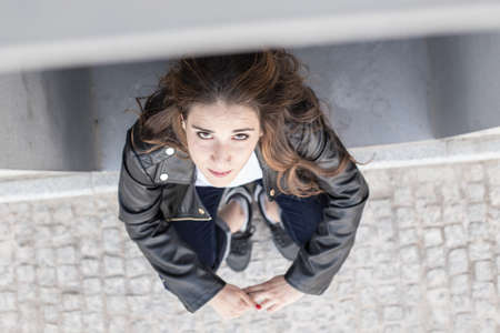 beautiful long-haired woman looking up with leather jacket