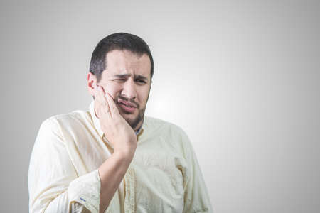 man with hand on face for toothache
