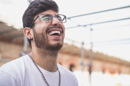guy with glasses laughing on the street