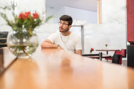 guy sitting in a bar with a jar