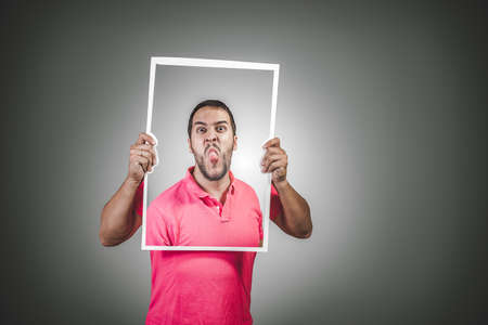 young man sticking out her tongue in a provocative wayの写真素材