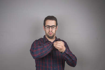 Portrait of man buttoning his checked shirt